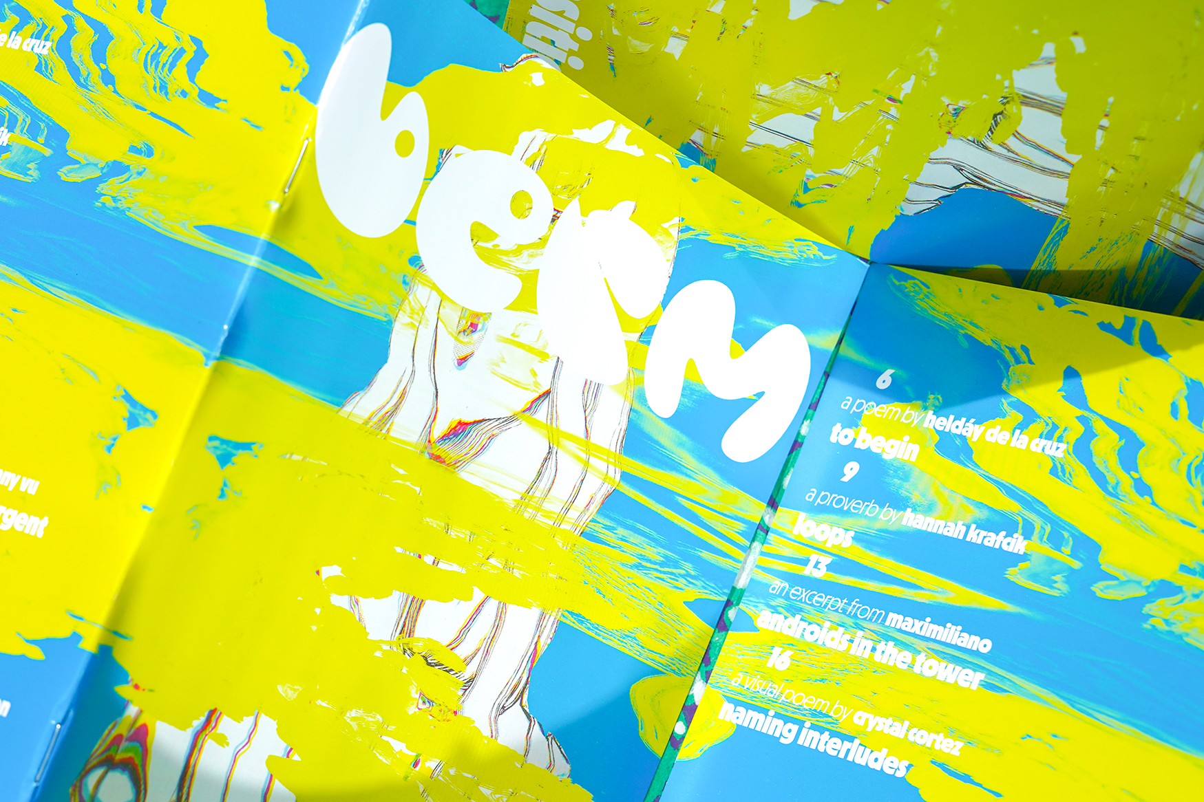 Several copies of Berm issue one, open showing both covers. The spine pushes up slightly.